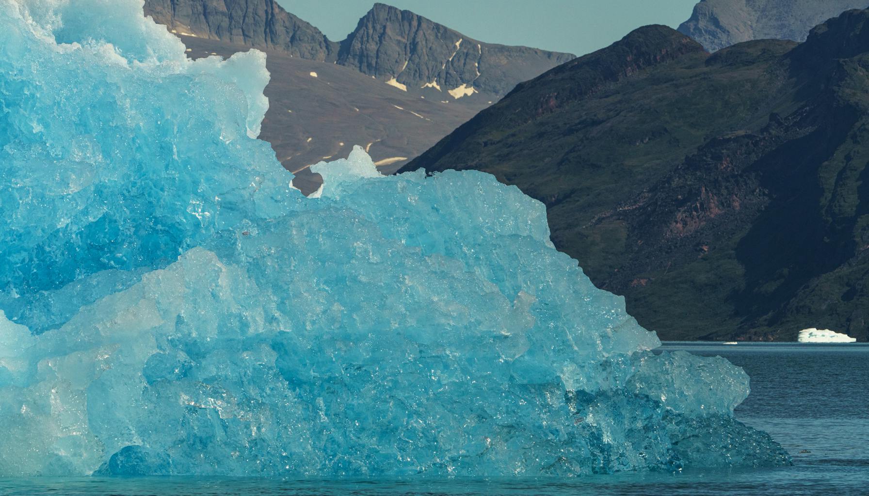 Rugged Greenland coastline with icy waters and dramatic mountain terrain